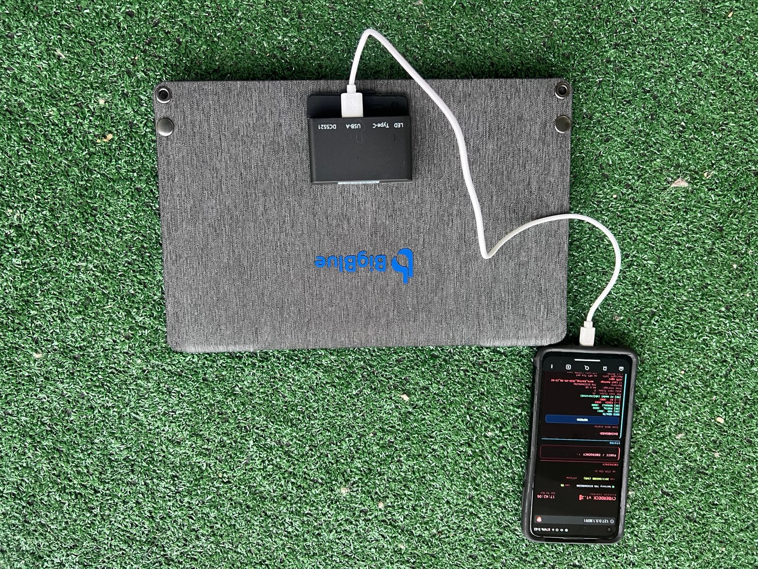 Back of my folded grey BigBlue panel, showing its controller and the cable connected to the cyberdeck phone.