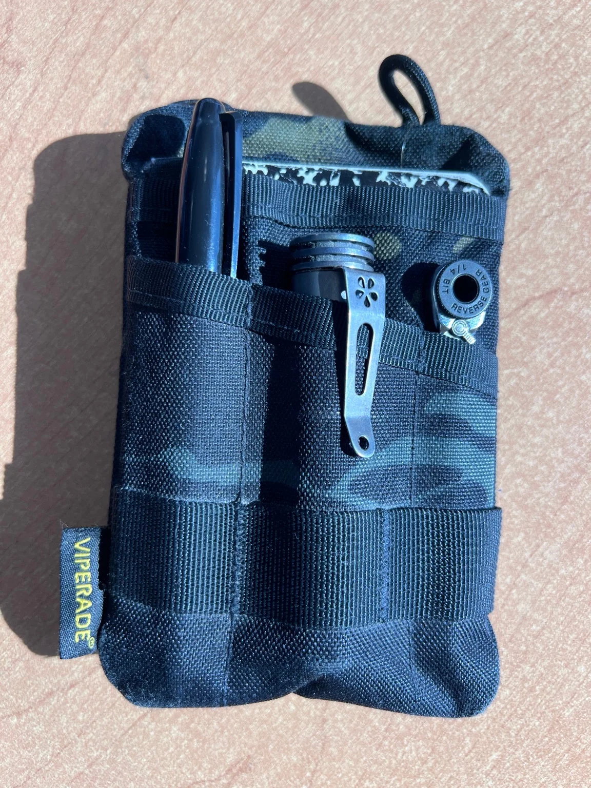 Black Viperade pocket organizer holding tools, with its fabric pockets, elastic straps, and yellow brand tag visible.